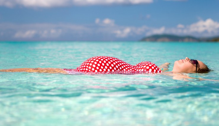 شنا در بارداری - زنی باردار شناور روی آب