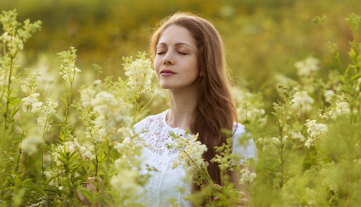 روانشناسی عطر - زنی در حال بوکردن گل‌ها